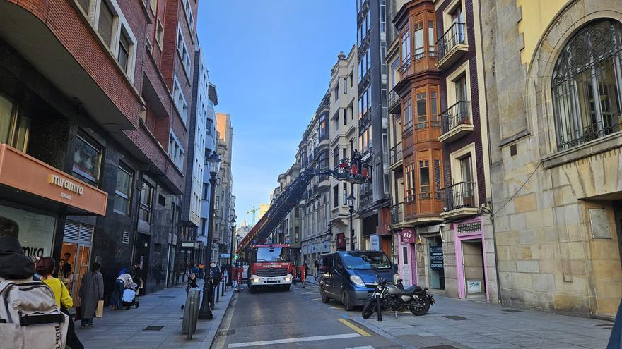Los bomberos retiran las letras del céntrico edificio Roma en Gijón