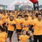 Una marea naranja tiñe Gijón de solidaridad contra el cáncer infantil: «Debemos apoyar esta causa»