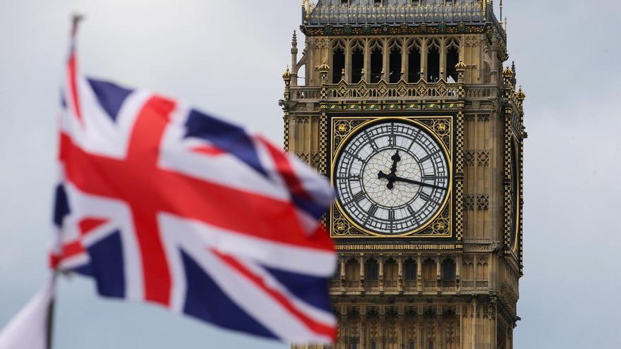 Un hombre trepa la torre del Big Ben portando una bandera de Palestina