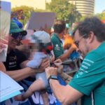 Fernando Alonso firma un autógrafo en un bebé durante el GP de Barcelona