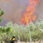 Bomberos luchan contra las llamas en el pavoroso incendio de la mota del río de Murcia
