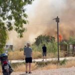 Algunos vecinos toman fotos de las llamas del incendio en El Malecón, Murcia
